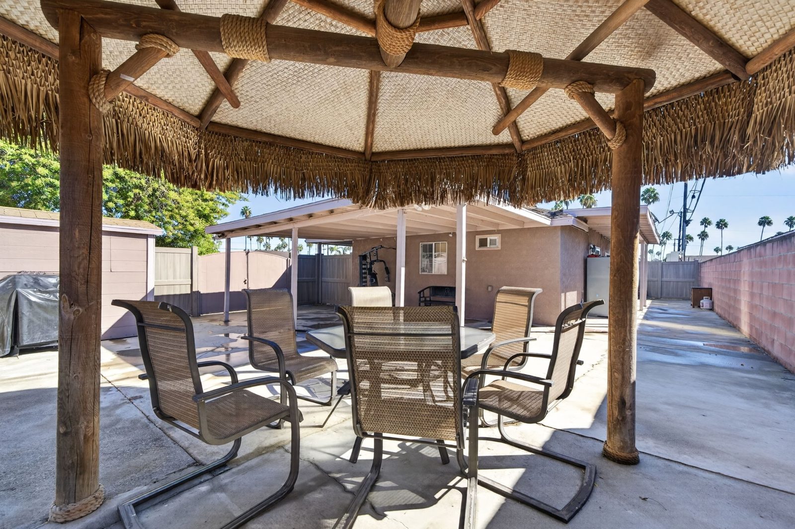 Covered rear patio with a palapa and seating for six